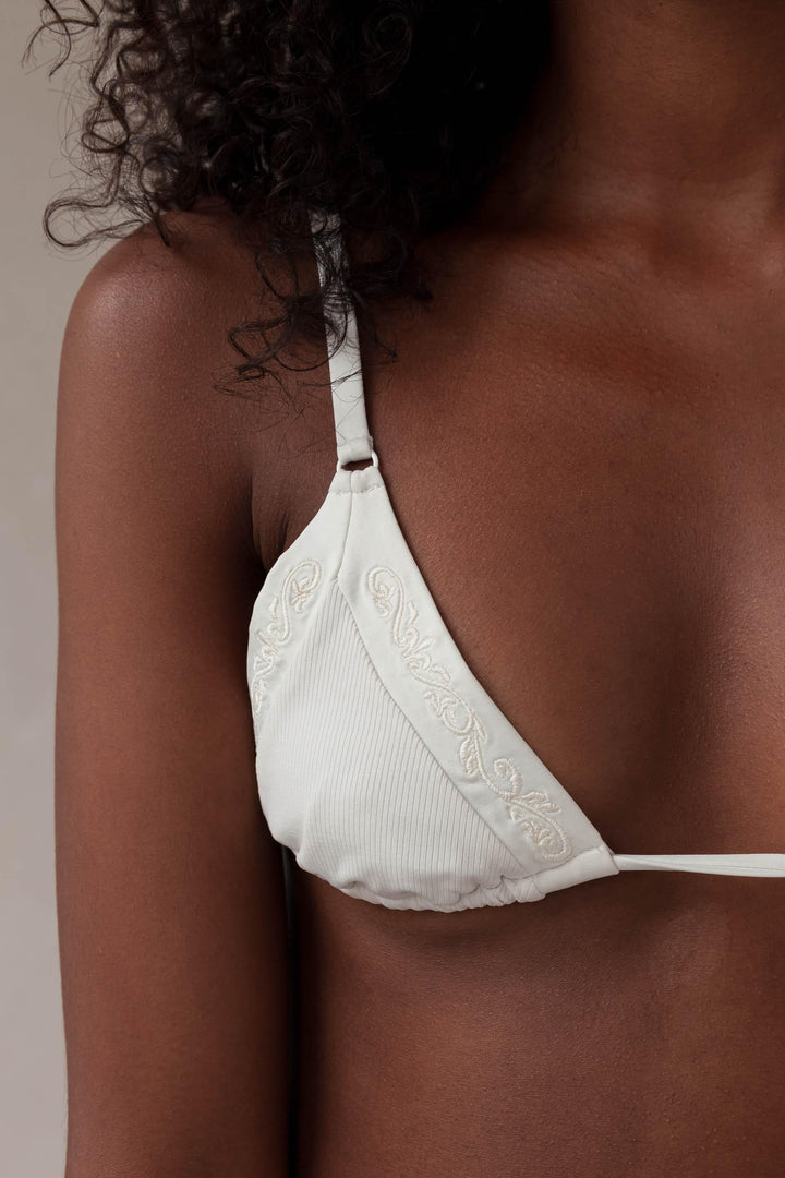 Close up embroidery and rib fabric on the triangle bikini top in ivory white